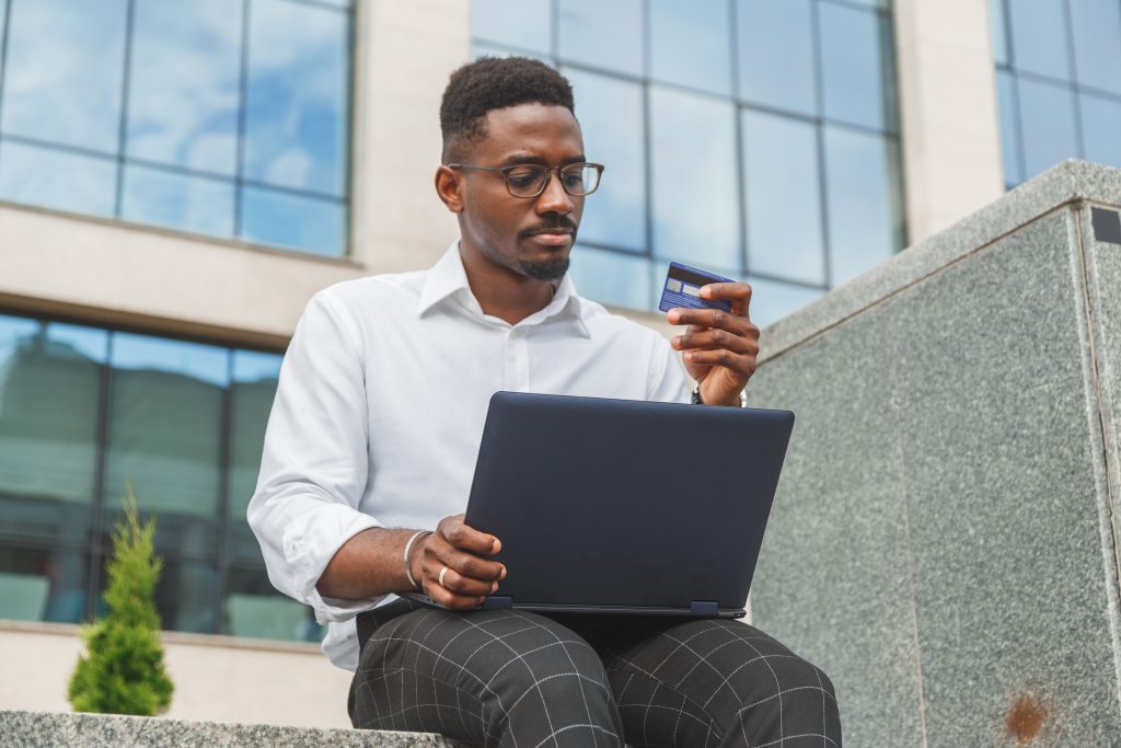 Man typing in his credit card details on a laptop.