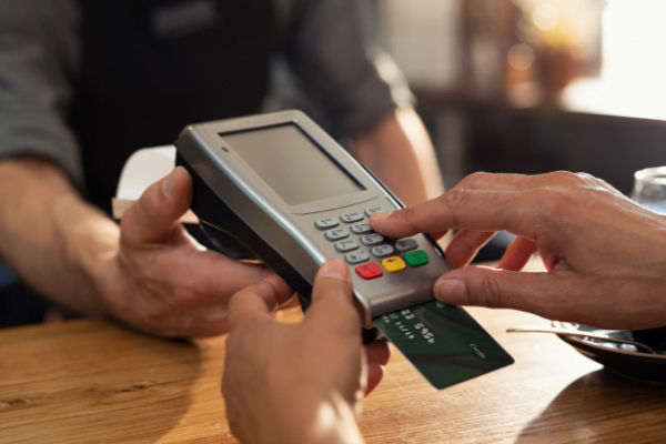 Man using a credit card machine at a cafe