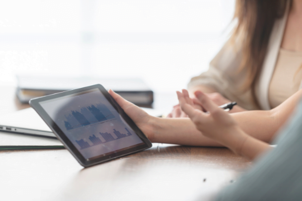 Two women looking at charts on a smart device