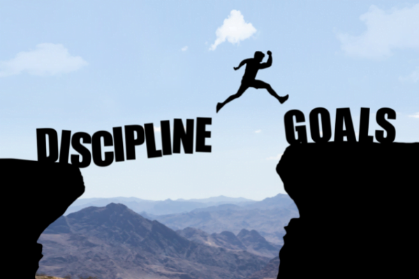 Person jumping from one cliff that says "discipline" to another that says "goals"