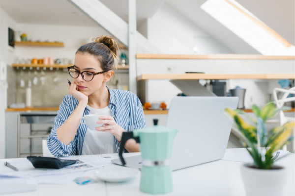 Woman working on her budget while having a coffee