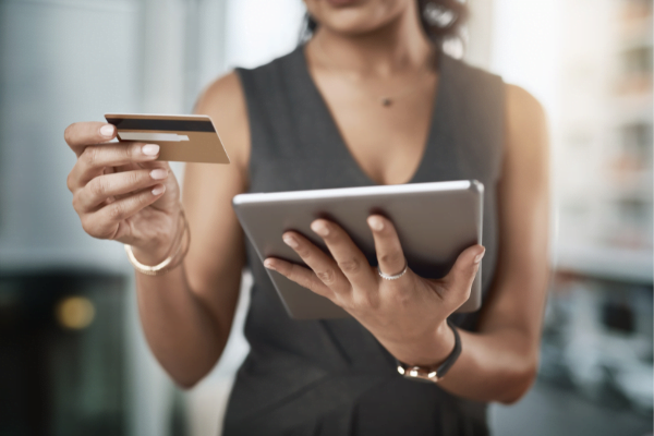 woman holding a credit card and a iPad